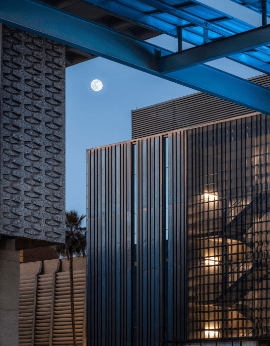 closeup ASU Student Pavilion Exterior of building at night with full moon in the background
